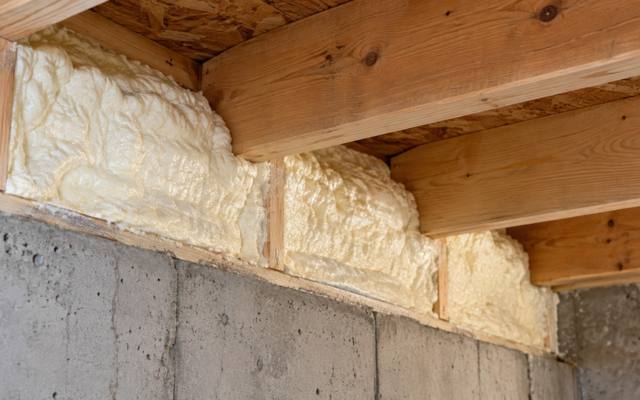 Rim joist sealed with spray foam above a concrete wall in Kitchener